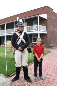 A Dayspring student stands with a soldier at Fort McHenry.